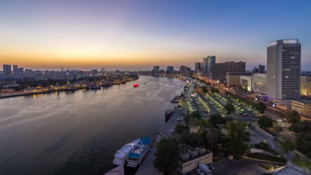 Dubai creek paisaje día a noche timelapse con barcos y barcos cerca del paseo marítimo — Vídeos de Stock