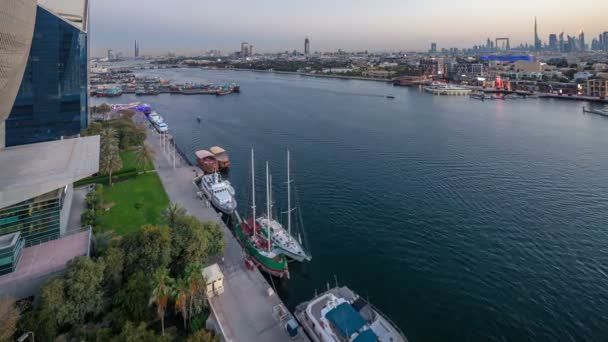 Dubai creek krajobraz dzień do nocy timelapse z łodzi i statków w pobliżu nabrzeża — Wideo stockowe