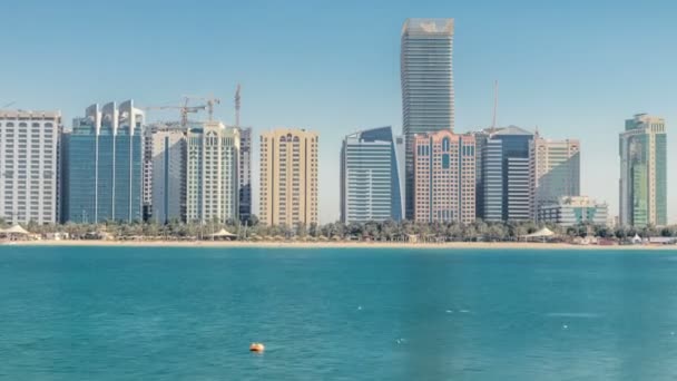 Zicht op hoge wolkenkrabbers op een corniche in Abu Dhabi die zich uitstrekt naast het business center timelapse. — Stockvideo