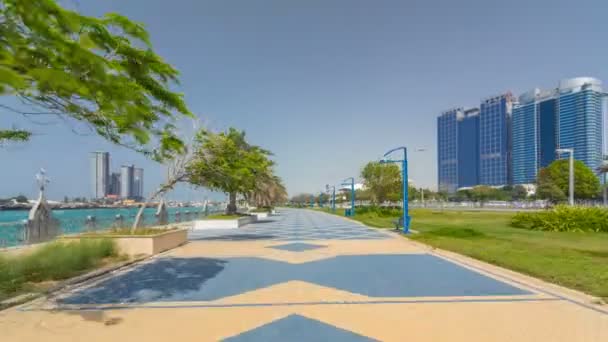 Corniche boulevard beach park lungo la costa di Abu Dhabi timelapse iperlapse con grattacieli sullo sfondo. — Video Stock