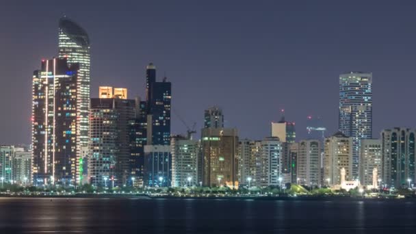 Vista panorámica del horizonte de Abu Dhabi y frente al mar por la noche timelapse, Emiratos Árabes Unidos — Vídeo de stock