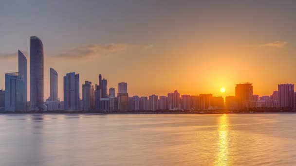 Abu Dhabi panorama miasta na wschodzie słońca z odbiciem wody timelapse. — Wideo stockowe