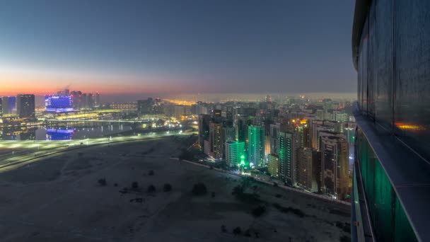 Skyline von Abu Dhabi mit Wolkenkratzern vor Sonnenaufgang von oben Nacht auf Tag Zeitraffer — Stockvideo