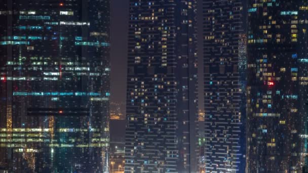 Ventana de los rascacielos de varias plantas de la iluminación de oficinas de vidrio y acero y personas dentro de timelapse — Vídeos de Stock