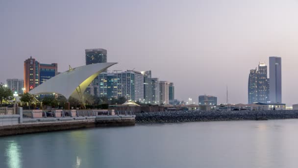 Promenade in Abu Dhabi verlicht in de schemering, dag tot nacht timelapse. — Stockvideo