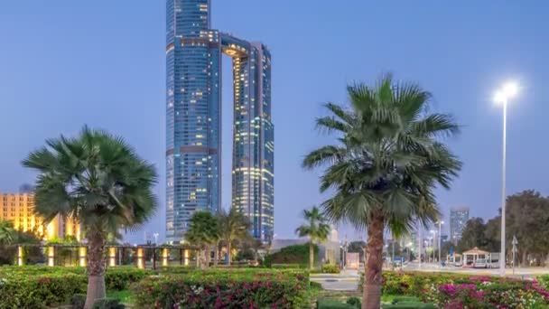 Rascacielos de Abu Dhabi iluminados con torres Nation edificios día a noche timelapse transición. — Vídeos de Stock