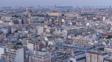 Paris 'teki evlerin çatılarının üstündeki hava manzarası, günden geceye zaman.