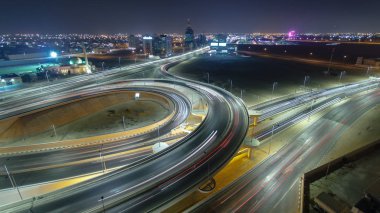 Pan ve ışıklar timelapse balıkgözü ile gece ana yola Üstgeçit çatı üzerinden trafik ile Cityscape Ajman tilt. Ajman Emirliği Ajman, Birleşik Arap Emirlikleri başkentidir. 4k