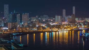 Ajman Gölü su yansıması ile Cityscape çatı gece timelapse, dan. Ajman Emirliği Ajman, Birleşik Arap Emirlikleri başkentidir. 4k