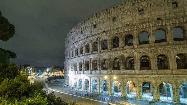 view of Colosseum illuminated at night timelapse hyperlapse in Rome, Italy. Top view. Traffic on the road