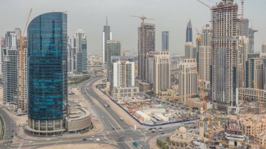 Downtown Dubai ve bay manzarası ile recidential ve ofis kuleleri timelapse, görüntülemek çatıdan iş. Bulutlu gökyüzü ve bir yolda trafik