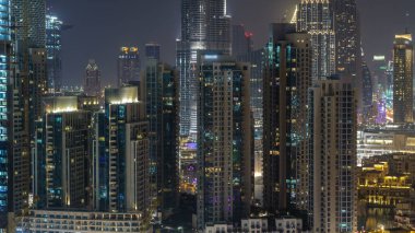 Işıklı modern mimarisi içinde Downtown, Dubai, Birleşik Arap Emirlikleri ile gece hava cityscape timelapse. Çatı görünümünden ışıklı finans bölgesi