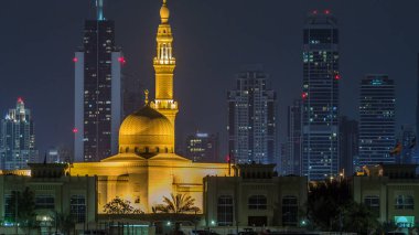 Modern Dubai şehir manzarası timelapse Rashid Al hadis Camii ile su yüzeyi üzerinde ışıklandırılmış gökdelenler ile gece. Daria adadan Dubai şehir merkezine görüntülemek