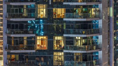 Dubai, Birleşik Arap Emirlikleri - Mart 2018 yaklaşık: Doğal parlayan windows akşam timelapse, gökdelenlerin. Dubai Yat Limanı modern konut yüksek katlı binaların görünümü. Daire içinde hareket insanlar. Hava üstten görünüm. Yukarı kaydır