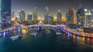 Dubai Yat Limanı gece timelapse, Glittering ışıklar ve açık bir akşam sırasında en yüksek gökdelenler. Işıklı kuleleri, yatlar ve arka plan üzerinde yolda trafik