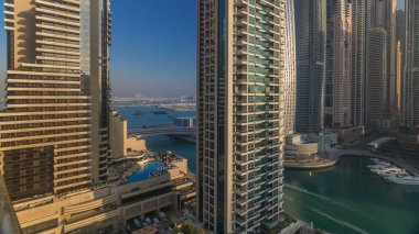 Modern gökdelenler ile Yatlar Dubai, Birleşik Arap Emirlikleri Dubai Marina gündoğumu ışıklar timelapse parlayan bir bakış. Camına yansıyan ışık ışınları.