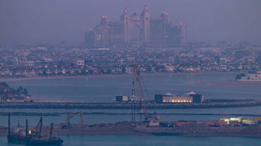 Gün geçiş timelapse için Palm Jumeirah geceden bir çatı, Dubai, Birleşik Arap Emirlikleri hava görünümünü. Ön plan üzerinde inşaat işleri