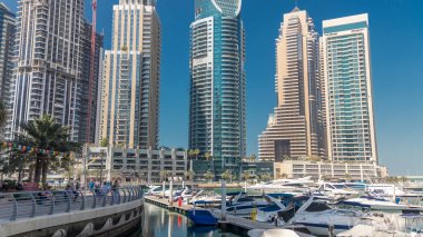 Dubai Yat Limanı bir tekne timelapse yatların defne. En yüksek gökdelenler kanal suya yansıyan. Mavi gökyüzü güneşli gün