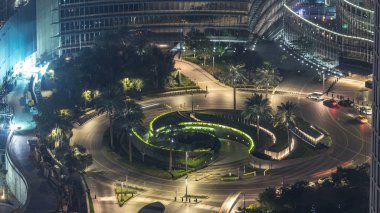 Dubai trafik ışıkları gökdelen yakın merkezi güzel çeşme ile gece timelapse Circle'da. Avuç içi ve ağaçları ile hava üstten görünüm