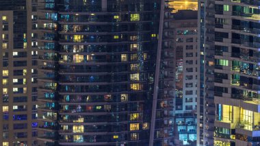 Akşam timelapse, gökdelenlerin parlayan windows. Dubai Yat Limanı modern konut yüksek katlı binaların görünümü. İnsanlar hareketli iç. Hava üstten görünüm. Yakınlaştır