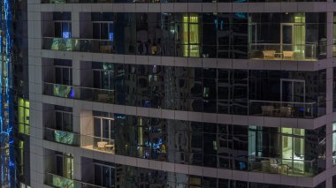 Akşam timelapse, gökdelenlerin parlayan windows. Dubai Yat Limanı modern konut yüksek katlı binaların görünümü. Daire içinde hareket insanlar. Hava üstten görünüm. Sağa çevir