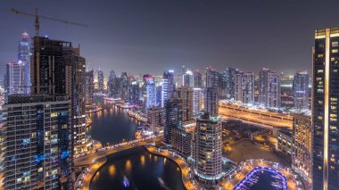 Dubai Yat limanı manzarası, gece timelapse üzerinde su kanalı. Konut kuleleri aydınlatma ve aydınlatma ile. Yat ve tekne trafiği olan gökdelenler yüzen