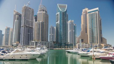 Panoramik manzaralı modern gökdelenler ve Dubai Marina timelapse yatlara ile su iskelesi ile set güneşli gün görüntülemek. Birleşik Arap Emirlikleri