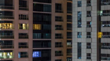 Akşam timelapse, gökdelenlerin parlayan windows. Dubai Yat Limanı modern konut yüksek katlı binaların görünümü. Daire içinde hareket insanlar. Hava üstten görünüm. Vınlamak dışarı