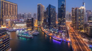 Dubai, Birleşik Arap Emirlikleri güneş battıktan sonra gece geçiş timelapse tüm Dubai Yat Limanı mesire ve kanal kayan yat ve tekne ile günler güzel hava üstten görünüm. Modern kuleleri ve Köprüde trafik.