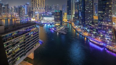 Dubai Yat limanı manzarası, gece timelapse üzerinde su kanalı. Konut kuleleri aydınlatma ve aydınlatma ile. Yat ve tekne trafiği olan gökdelenler yüzen