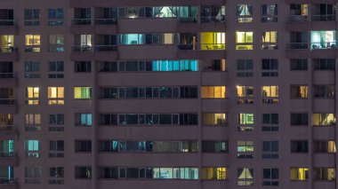 Akşam timelapse, gökdelenlerin parlayan windows. Görünümü office yüksek katlı binalarda Dubai Yat Limanı ve modern konut. İnsanlar hareketli iç. Hava üstten görünüm. Sağa çevir