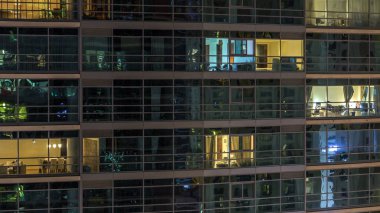 Akşam timelapse, gökdelenlerin parlayan windows. Görünümü office yüksek katlı binalarda Dubai Yat Limanı ve modern konut. İnsanlar hareketli iç. Hava üstten görünüm. Vınlamak dışarı