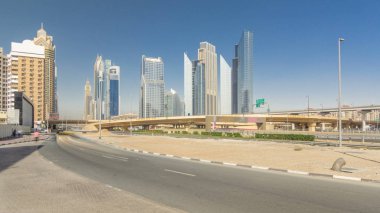 Meşgul Şeyh Zayed Caddesi üzerinde trafik timelapse hyperlapse, metro demiryolu Üstgeçit kavşağı ve çevresinde modern gökdelenler lüks Dubai City, Birleşik Arap Emirlikleri. Mavi gökyüzü ile güneşli açık gün