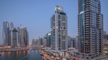 Dubai, Birleşik Arap Emirlikleri güneş battıktan sonra gece geçiş timelapse Dubai Yat Limanı mesire ve kanal kayan yat ve tekne ile günler hava üstten görünüm. Modern kuleleri ve trafik