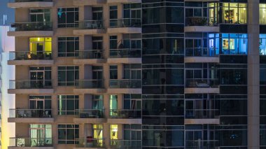 Gece timelapse, gökdelenlerin parlayan windows. Dubai Yat Limanı modern konut yüksek katlı binaların görünümü. İnsanlar hareketli iç. Hava üstten görünüm.