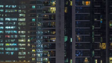 Gece timelapse, gökdelenlerin parlayan windows. Görünümü office yüksek katlı binalarda Dubai Yat Limanı ve modern konut. İnsanlar hareketli iç. Hava üstten görünüm.