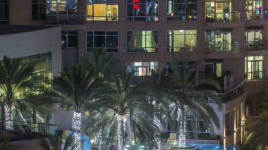 Dubai Yat Limanı gece timelapse aydınlatmalı çatı yüzme havuzu. Gökdelen hava en iyi manzara. Bir mesire avucunda. Recidential Kulesi içinde parlayan pencere eşiği