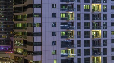 Windows çok katlı binanın içinde aydınlatma ve insanlar timelapse içinde hareketli çelik ve cam. Dubai Yat Limanı içinde modern konut gökdelenler hava görünümünü. Yakınlaştır