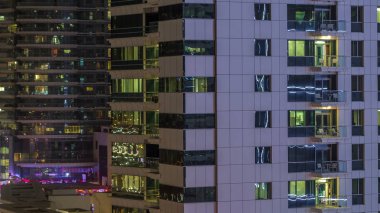 Windows çok katlı binanın içinde aydınlatma ve insanlar timelapse içinde hareketli çelik ve cam. Dubai Yat Limanı içinde modern konut gökdelenler hava görünümünü. Sağa çevir