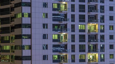 Windows çok katlı binanın içinde aydınlatma ve insanlar timelapse içinde hareketli çelik ve cam. Dubai Yat Limanı içinde modern konut gökdelenler hava görünümünü. Aşağı kaydır