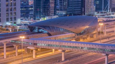 Gün geçiş timelapse Şeyh zayed road ve metro hattı üzerinde trafik ile gecesine ışıklandırılmış gökdelenler ile havadan görünümü Jumeirah Göl yakınındaki Metro İstasyonu kuleleri. Dubai Yat Limanı güneş doğmadan önce çatı görünümü