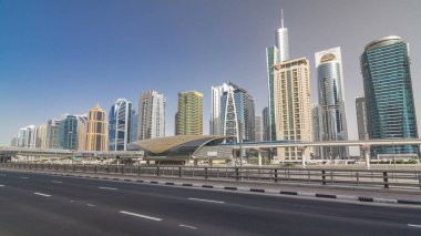 Sheikh zayed road ve tramvay hattı üzerinde görünümü Jumeirah lakes towers gökdelenler ve metro sration timelapse hyperlapse trafik ile. Mavi gökyüzü ile güneşli gün