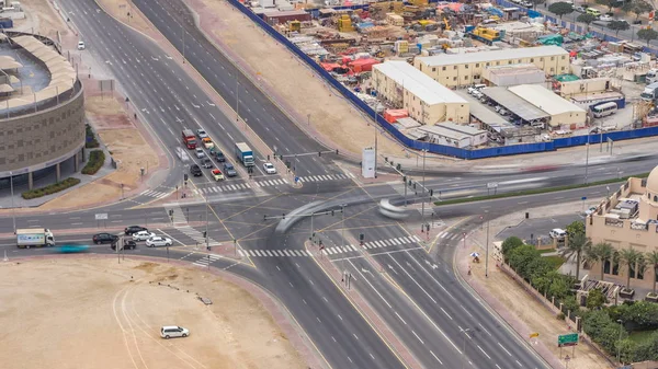 Top view city traffic on a crossroad in Dubai Downtown timelapse. Aerial top view of road junction from above, automobile traffic and jam of many cars, transportation concept