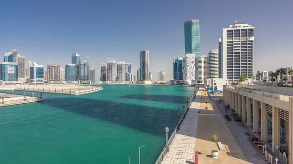 Panoramic timelapse hyperlapse view of business bay and downtown area of Dubai. Modern skyscrapers reflected in water and blue sky. Top view from bridge