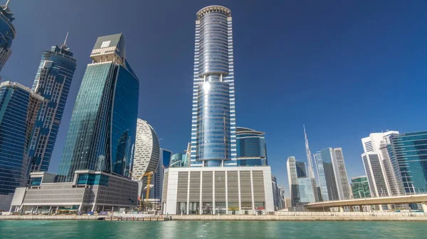 Panoramic timelapse hyperlapse view of business bay and downtown area of Dubai. Modern skyscrapers reflected in water and blue sky