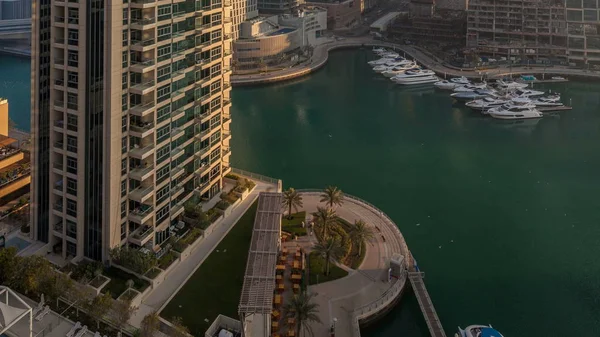 Modern gökdelenler ile Yatlar Dubai, Birleşik Arap Emirlikleri Dubai Marina gündoğumu ışıklar timelapse parlayan bir bakış. Camına yansıyan ışık ışınları.