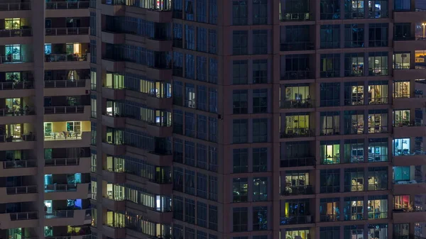 夜のタイムラプスで高層ビルの風光明媚な光る窓 ドバイ マリーナに近代的な高層住宅の眺め はアパート内を移動します 空中の平面図です 下にパンします — ストック写真