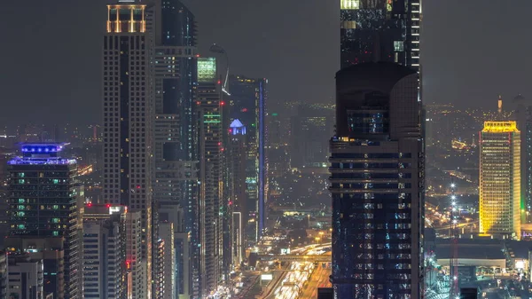 ドバイ ダウンタウン高層ビルの夜タイムラプス近代的高層ビル屋上でドバイ アラブ首長国連邦から平面図を点灯します 金融の中心地に近いシェイク ザイード ロード上のトラフィック — ストック写真