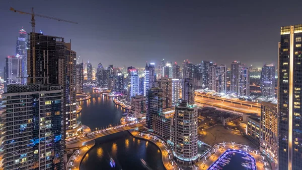 Timelapse 晚上在迪拜滨海地平线上的运河 带有照明和照明的住宅大楼 漂浮的游艇和在摩天大楼附近交通的小船 — 图库照片