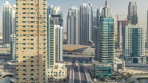 Amazing colorful dubai marina and JLT skyline during sunset timelapse. Great perspective of multiple tallest skyscrapers of the world with metro station. Sunlight over buildings. United Arab Emirates.